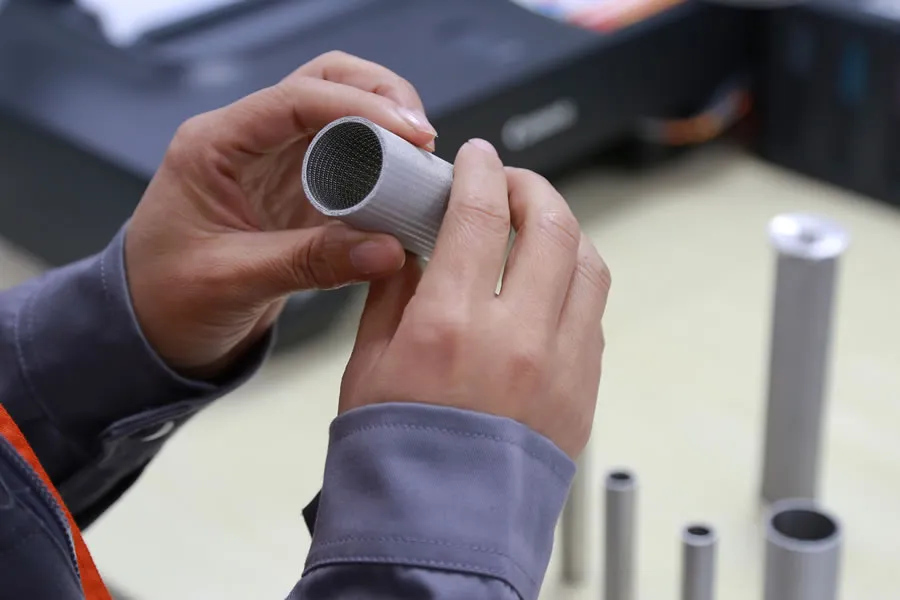 Inspecteur vérifiant la surface et les couches internes d’un tube filtrant en métal fritté