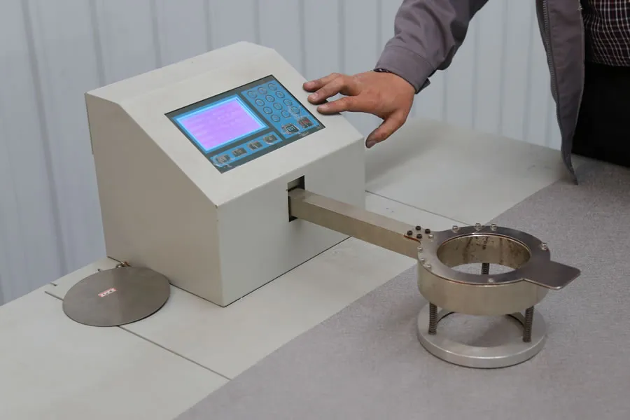 Technicien utilisant un équipement de test avec un porte-échantillon circulaire de toile métallique